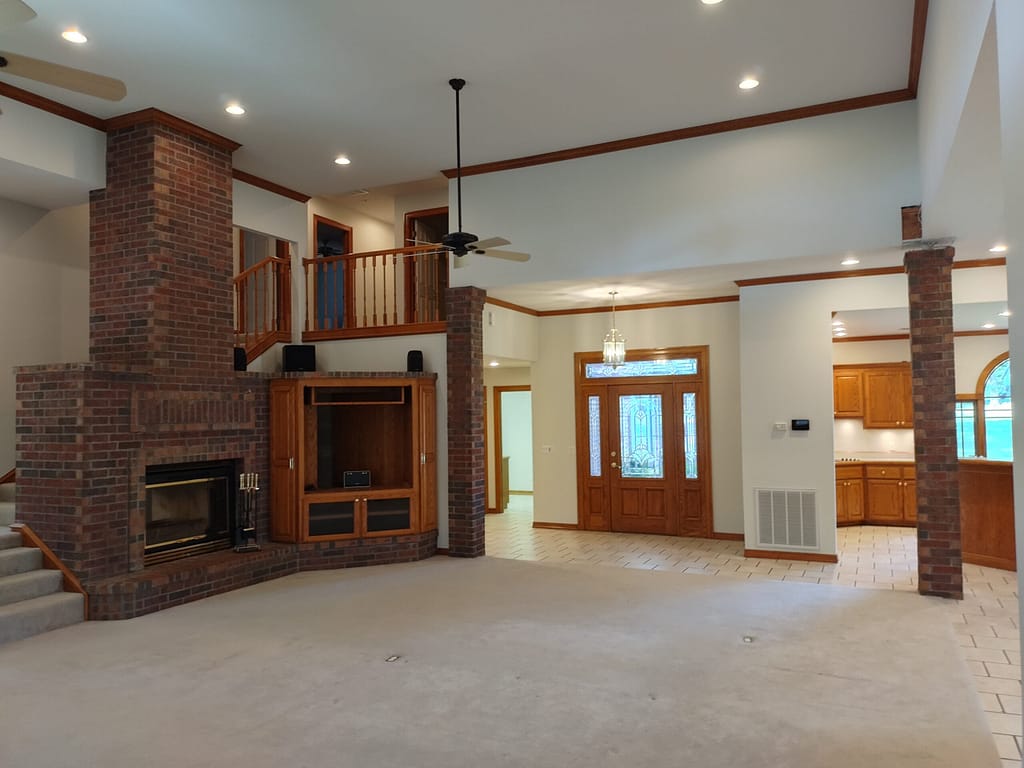 Large living room with fireplace and balcony before remodel
