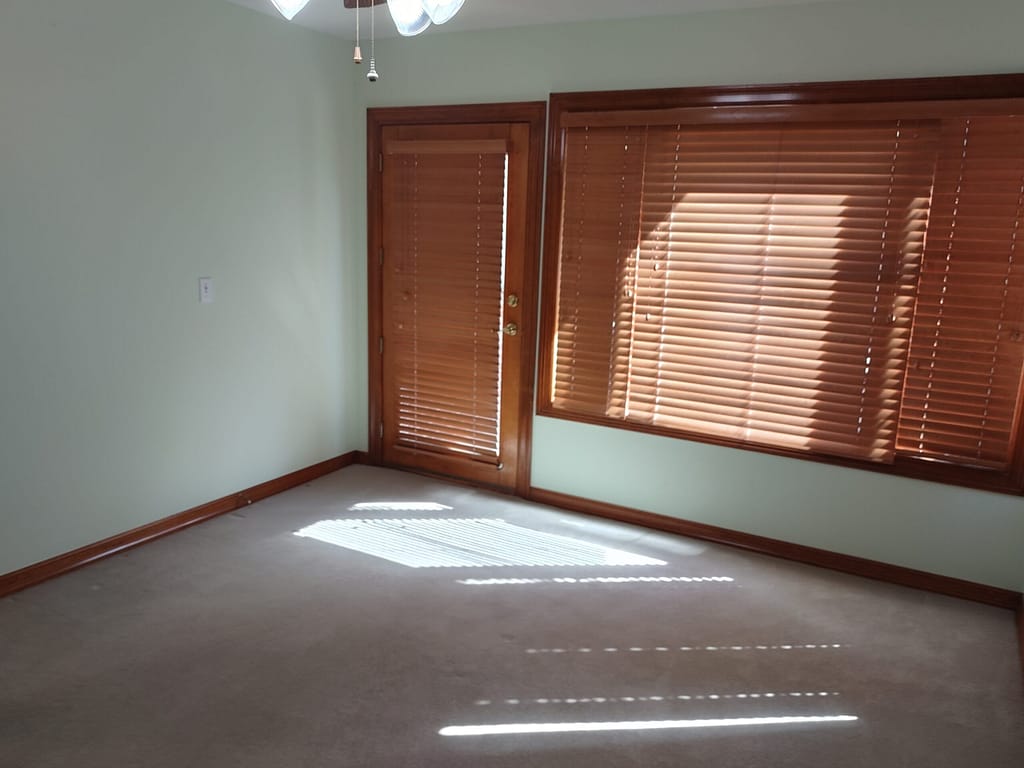 Bedroom with window and exterior door before remodel