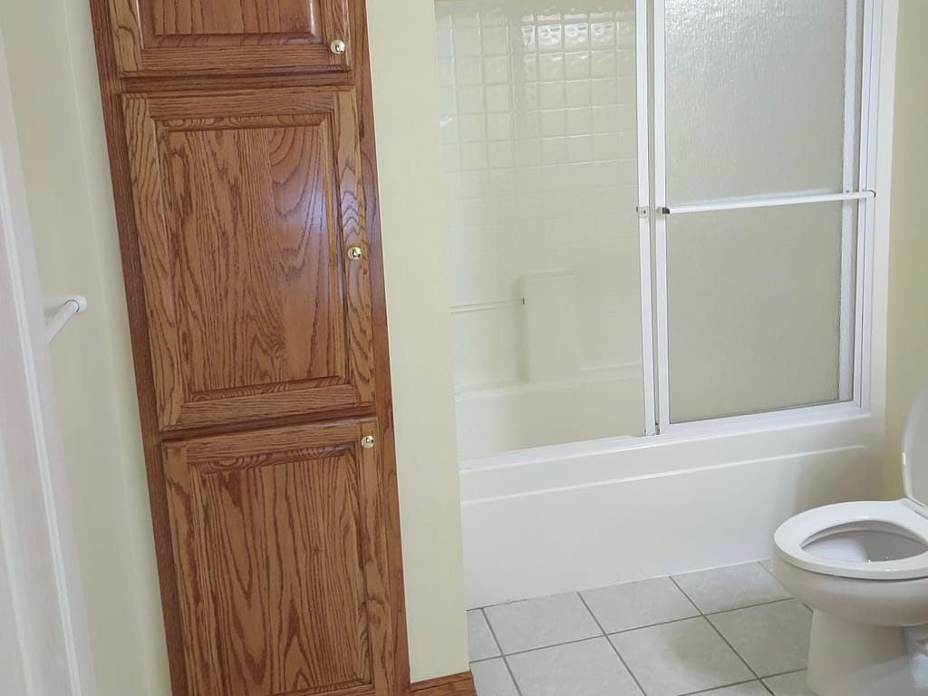 Bathroom with towel cabinet and shower before remodel