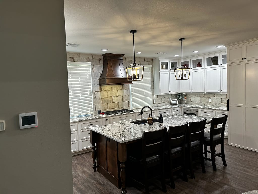 Kitchen with island and wooden oven hood after remodel