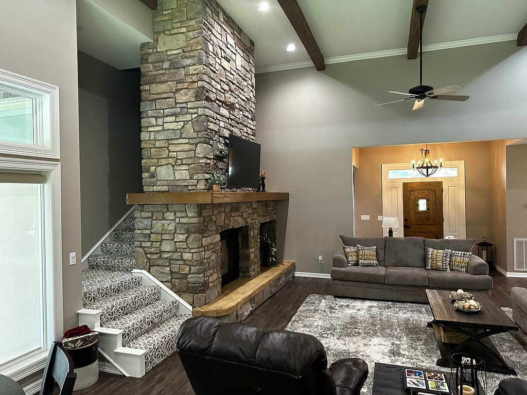 Large living room with fireplace and beams after remodel