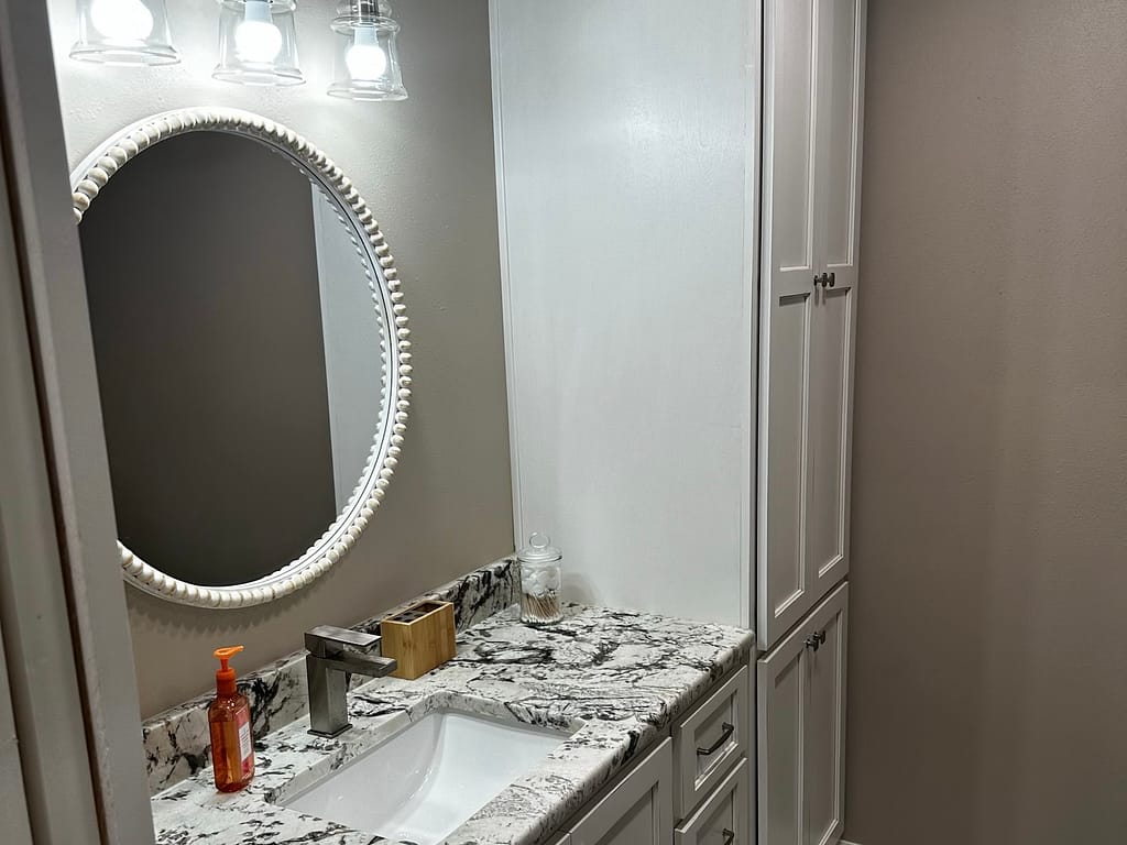 Bathroom with single vanity and towel cabinet after remodel